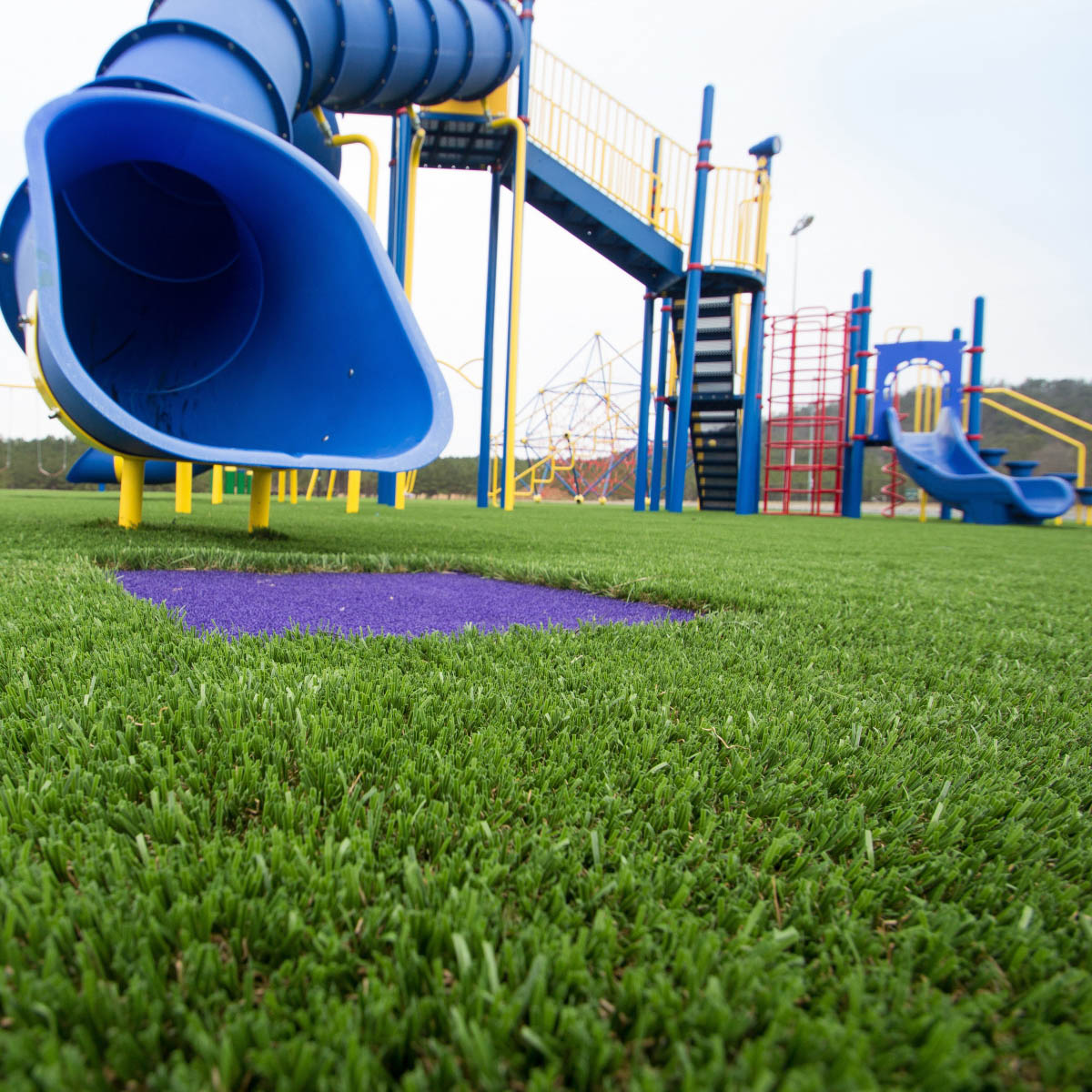 Artificial playground grass with blue slide