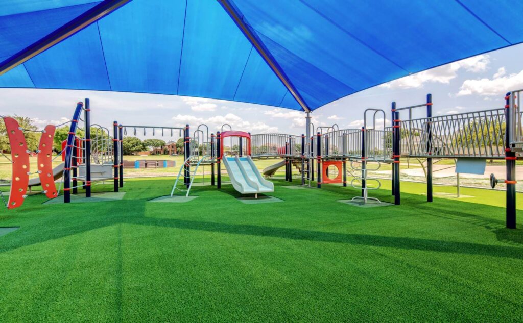 Blue slide installed on artificial playground grass