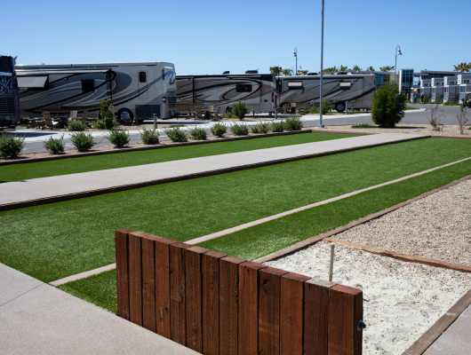 RV park next to artificial grass bocce court and park bench