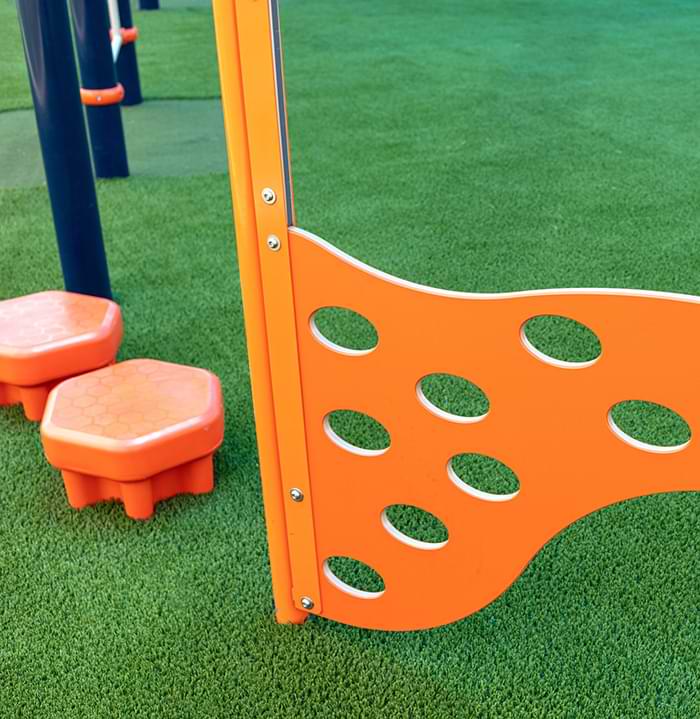 Orange playground equipment on artificial grass