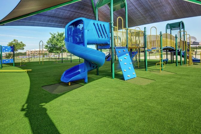 Blue slide on artificial playground grass